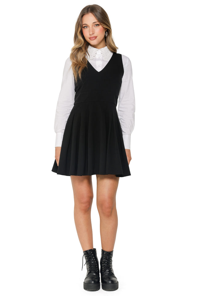 Woman wearing a black dress over a white shirt on a white background