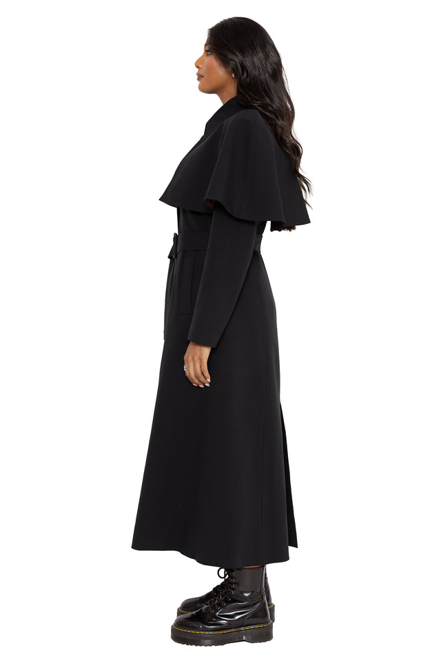 Gothic longline trench coat with hidden occult inspired lining and removable cape detailing for versatile layered styling. This corporate goth coat combines minimalist black fashion with dark fairycore and modern witch aesthetics.