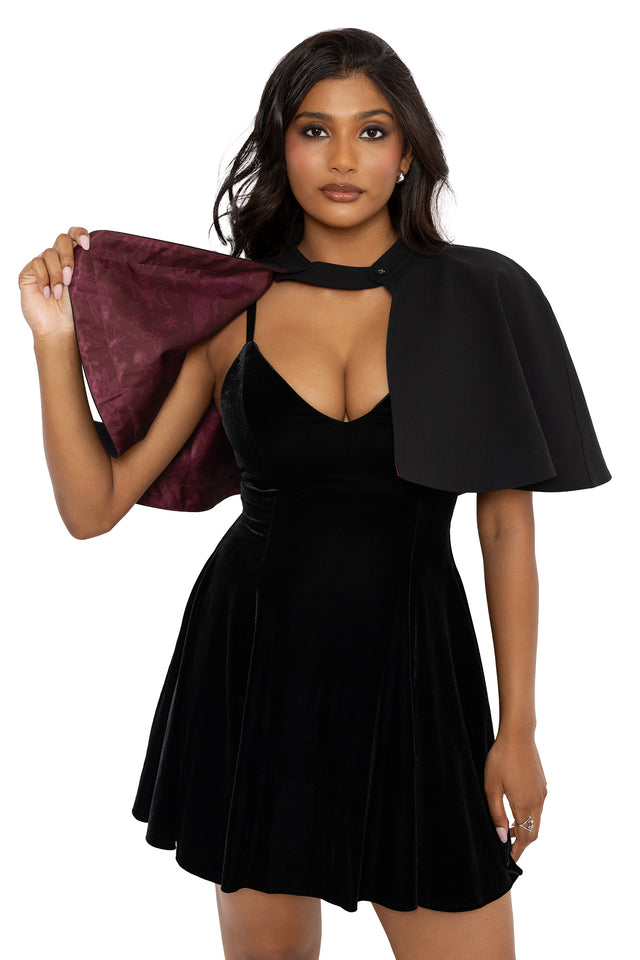 Black academy trench coat with hidden spellbook inspired lining and removable cape detail in a sleek gothic silhouette. This alternative goth outerwear piece captures corporate witch, whimsigoth and dark academia fashion from the Nature of a Witch collection.