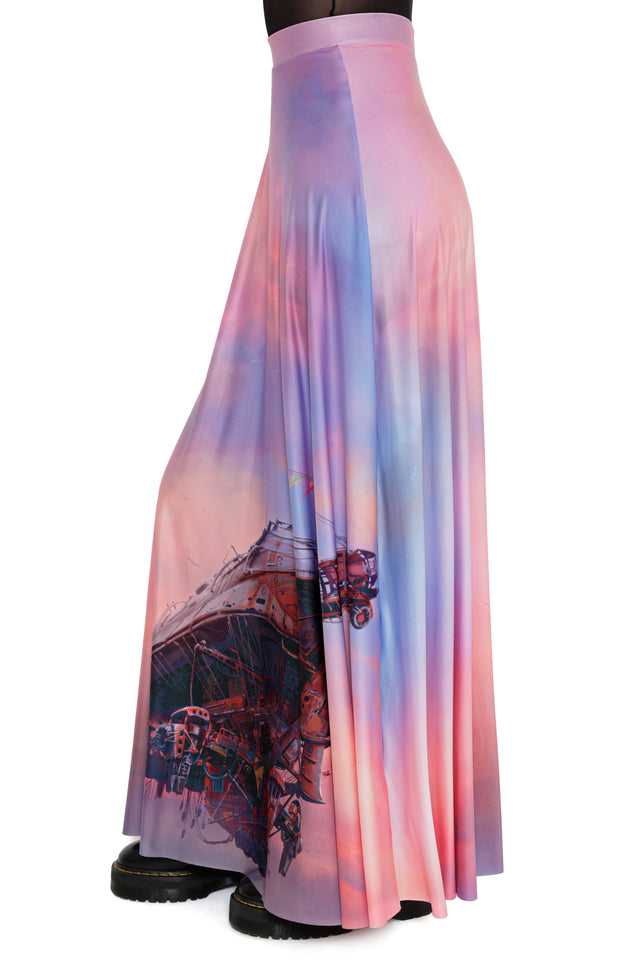 Model styled in Fallout x BlackMilk Ad Victoriam Maxi Skirt showcasing pink and lilac sky background with Fallout aircraft print.