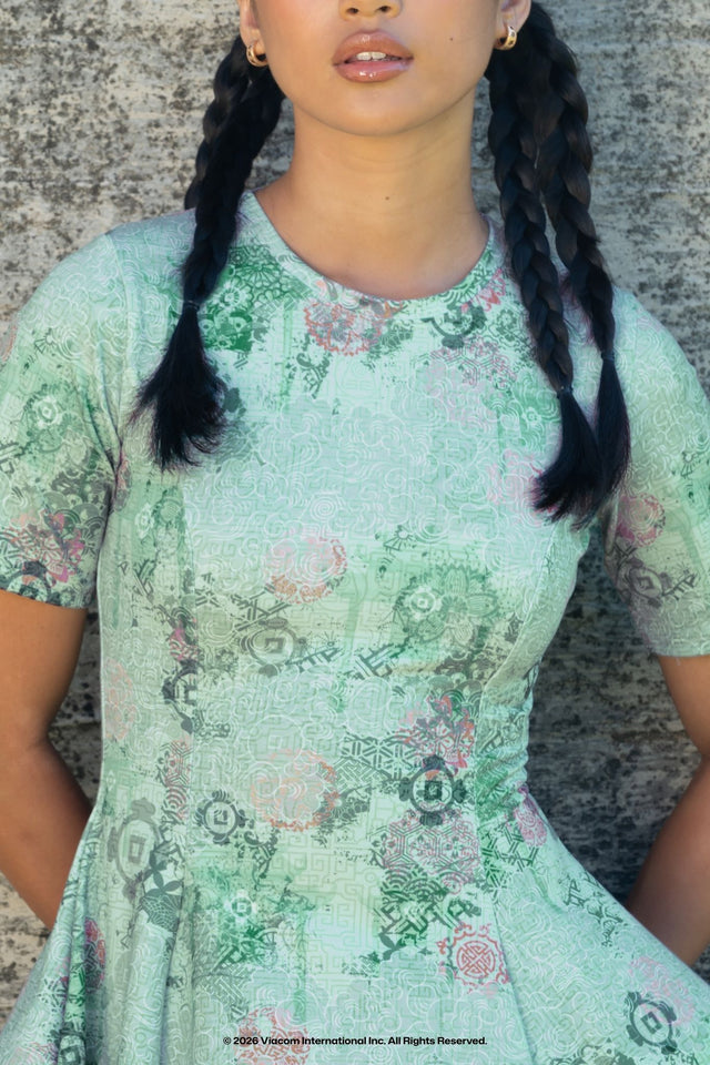 Model wearing Avatar: The Last Airbender x BlackMilk No War in Ba Sing Se Evil Tee Dress, Earth Kingdom inspired Avatar fashion with green all over print