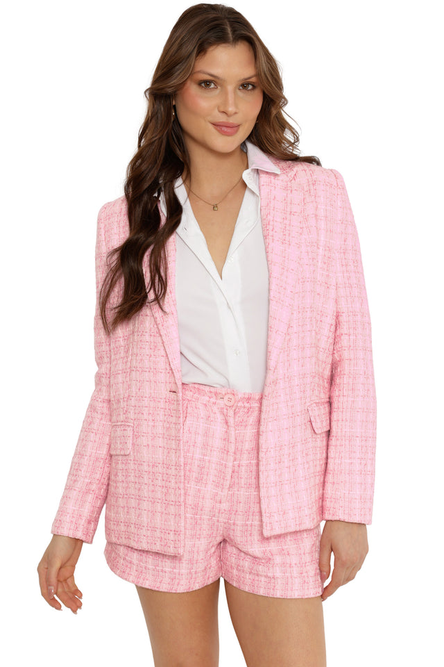 Woman wearing a pink checkered suit with a white shirt on a white background