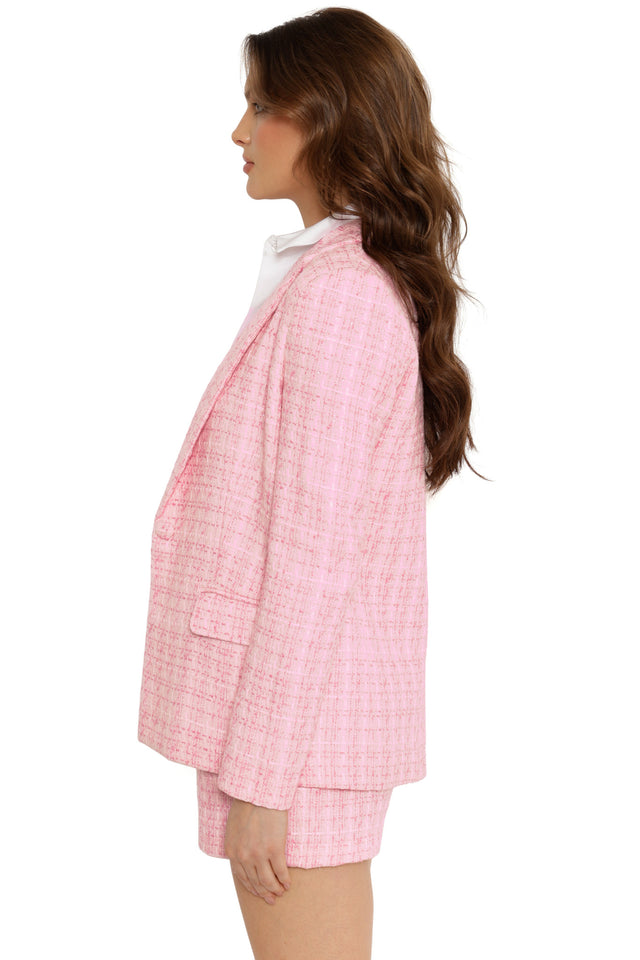Woman wearing a pink checkered suit on a white background