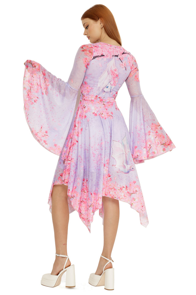 Lora Zombie Pearl in Sakura Spectre Dress with long flared sleeves, scoop neckline, and an asymmetric handkerchief hem.