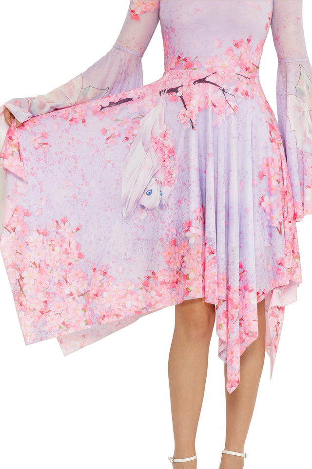 Lora Zombie Pearl in Sakura Spectre Dress with long flared sleeves, scoop neckline, and an asymmetric handkerchief hem.