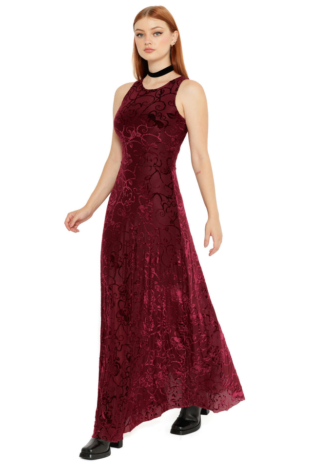 Model styled in the Be With Me Always Black Cherry Burned Velvet Princess Maxi Dress from the Wuthering Heights collection, showcasing a deep red velvet floral fabric, fitted bodice and flowing gothic silhouette