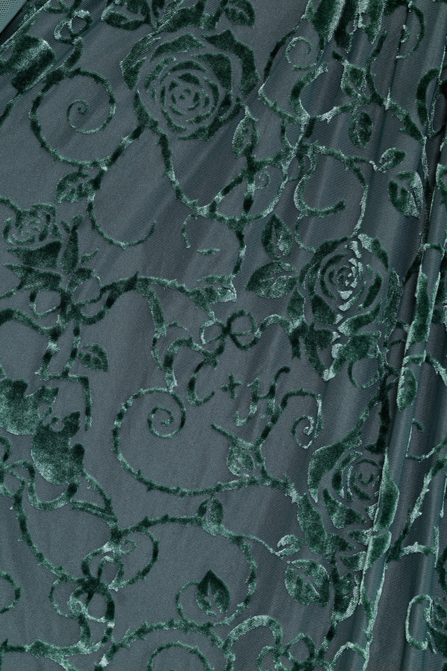 Model wearing the Be With Me Always Juniper Burned Velvet Sheer Romance Maxi Dress from the Wuthering Heights collection, a gothic romantic maxi dress with sheer long sleeves, deep v neckline, floral velvet texture and dramatic thigh split