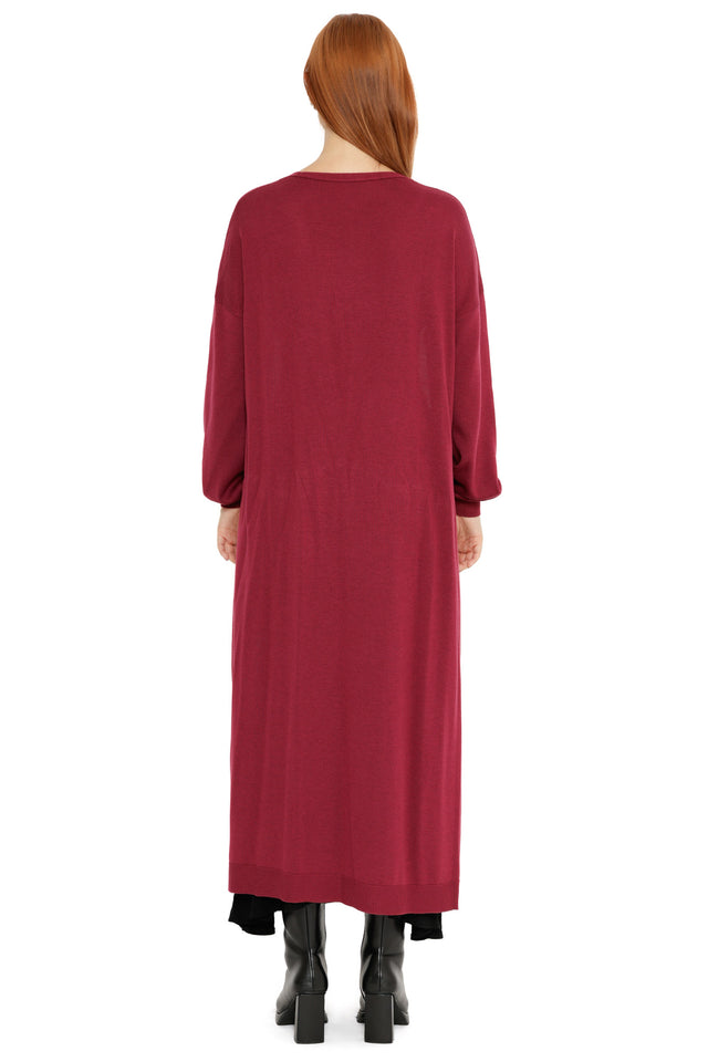 Berry Super Cardigan styled open over a black dress, showcasing the cosy longline length, relaxed sleeves and rich red tone