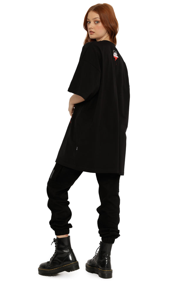 Person wearing a black oversized shirt, black pants, and black boots on a white background