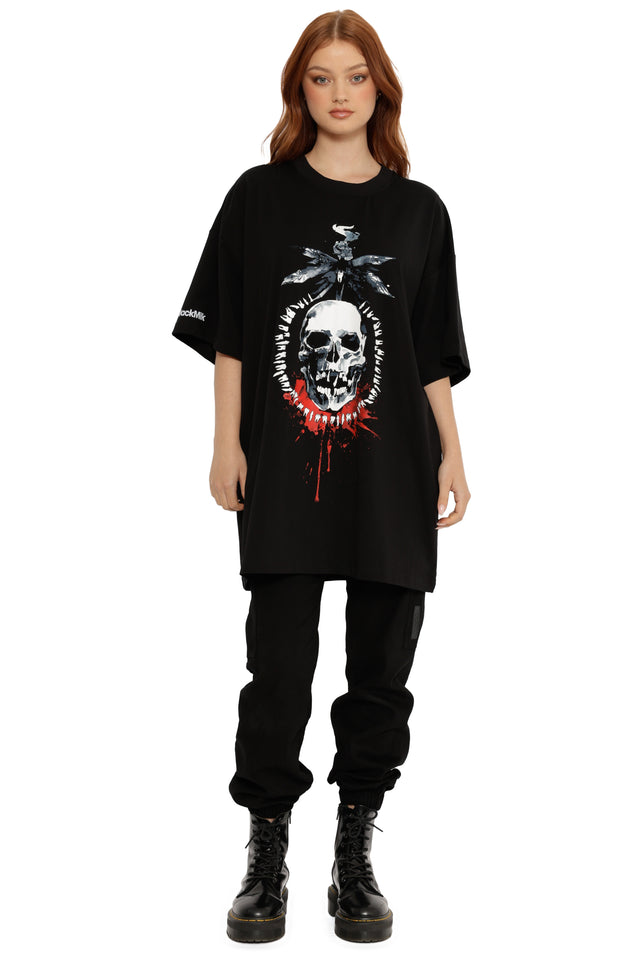 Person wearing a black oversized t-shirt with a graphic design on a white background