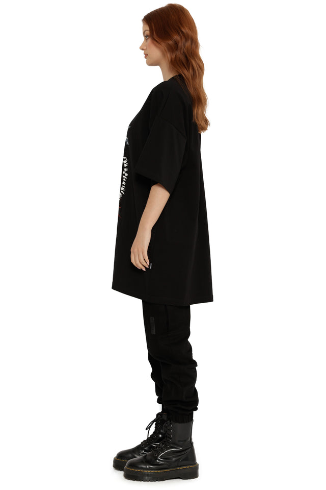 Person wearing a black oversized t-shirt and pants on a white background