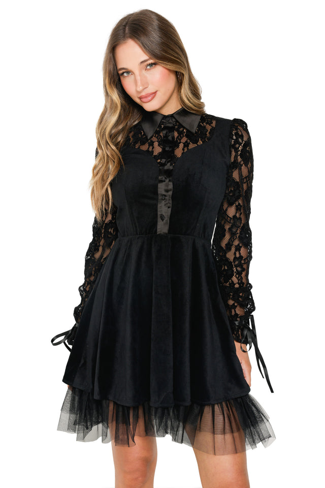 Woman wearing a black dress with lace details on a white background