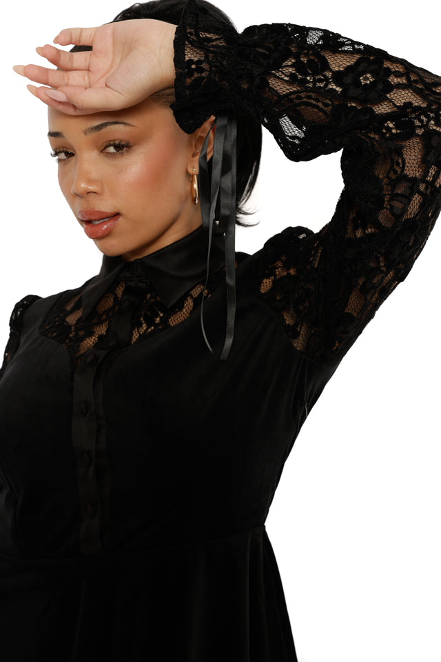 Woman wearing a black lace top with long sleeves on a white background