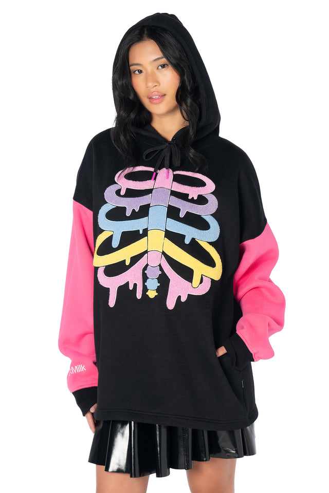 Unisex oversized skeleton hoodie with rainbow rib graphics, hot pink sleeves, heavyweight fleece lining, embroidered logos and a relaxed alternative fashion silhouette.