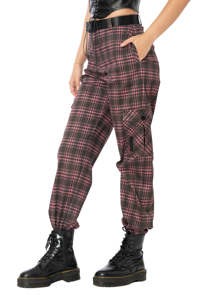 Bold pink tartan cargo pants featuring oversized utility pockets, adjustable removable buckle belt, vegan leather patch accents and elastic cuffed ankles for statement alternative streetwear and everyday comfort.
