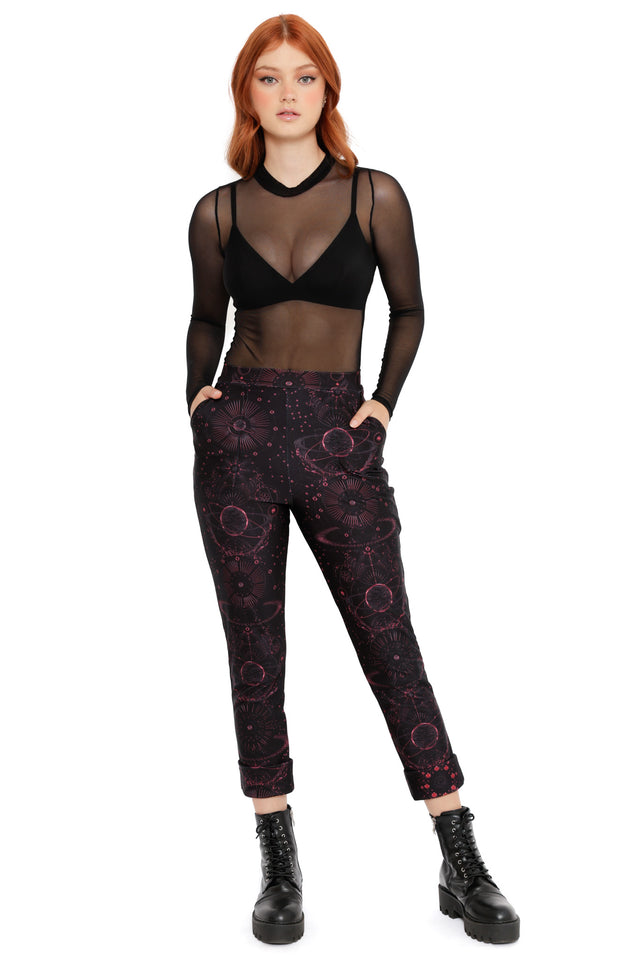 Black cuffed pants with deep red celestial and planet print, featuring cosmic symbols and a tapered fit