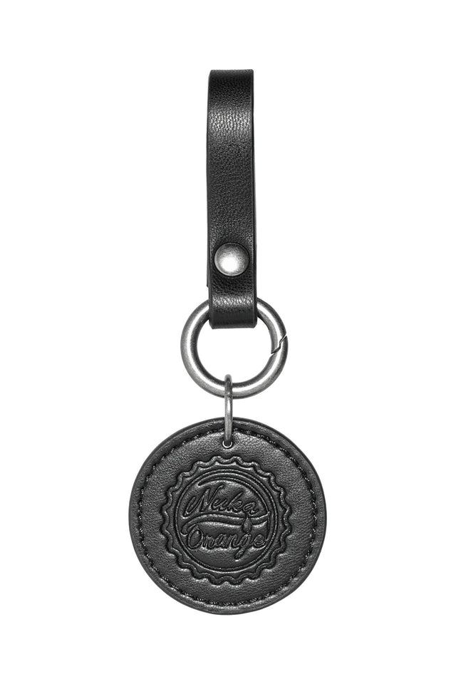 Flat lay of Fallout x BlackMilk faux-leather cap charms designed to clip onto the Cap Currency Belt.
