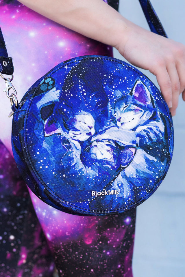 Round blue pouch with anime-style design held by a person against a galaxy-themed background.