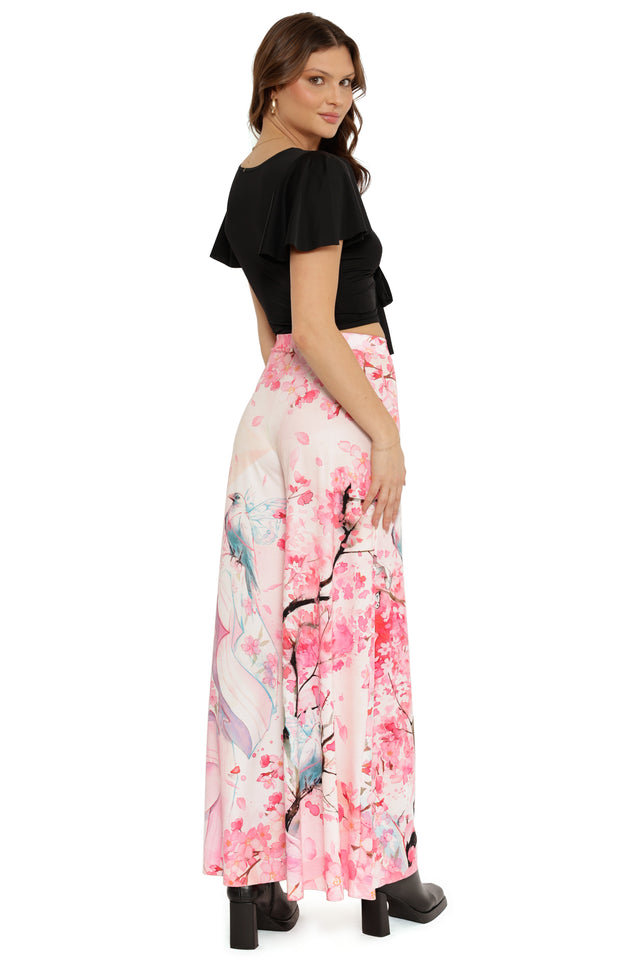 Woman wearing a black top and pink floral skirt on a white background