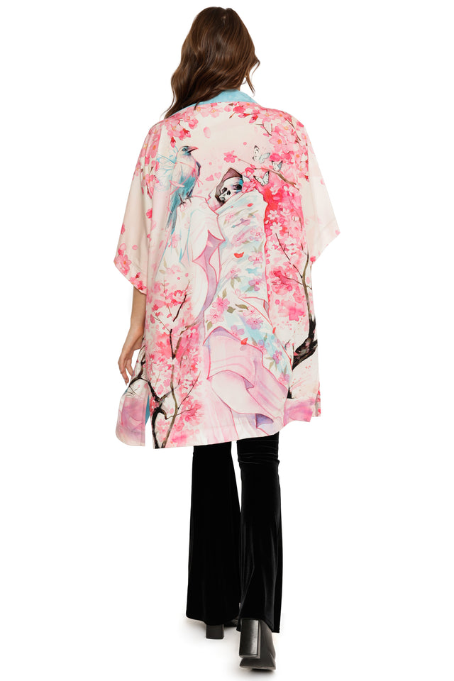 Woman wearing a kimono with floral and bird design on a white background