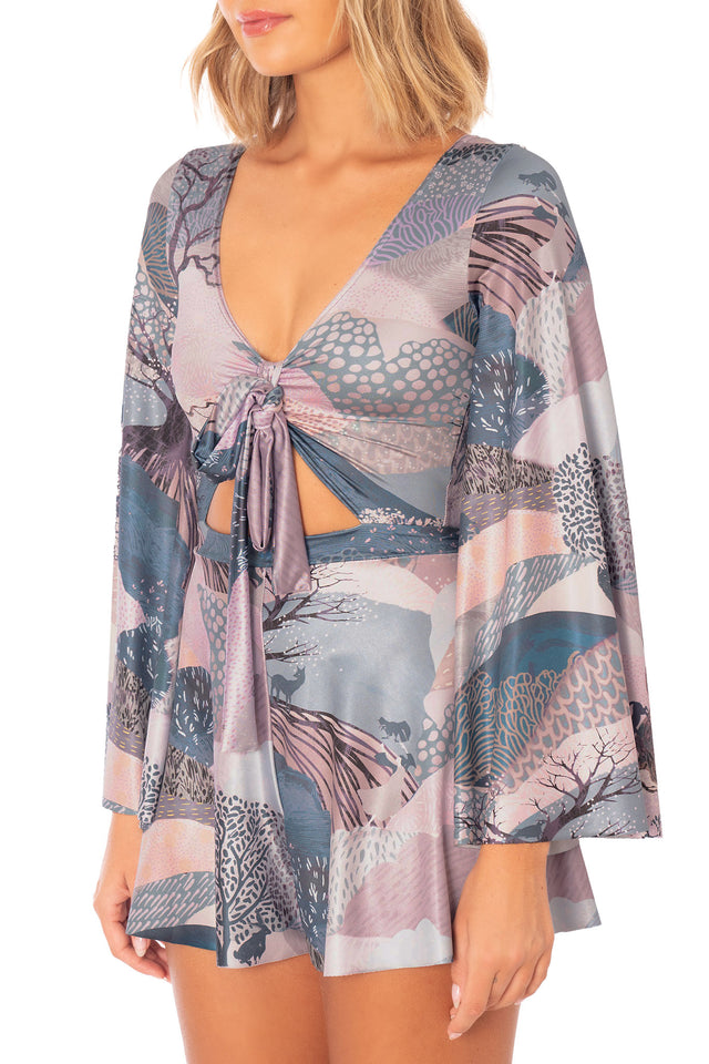 Front close image of Edge of Night Long Sleeve Rio Playsuit with flared sleeves, fitted waist and dreamy landscape print