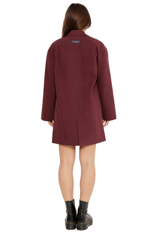 Model styled in Fallout x BlackMilk Enjoy Your Stay Duster Jacket inspired by Fallout New Vegas with embroidered Vault Boy motif.