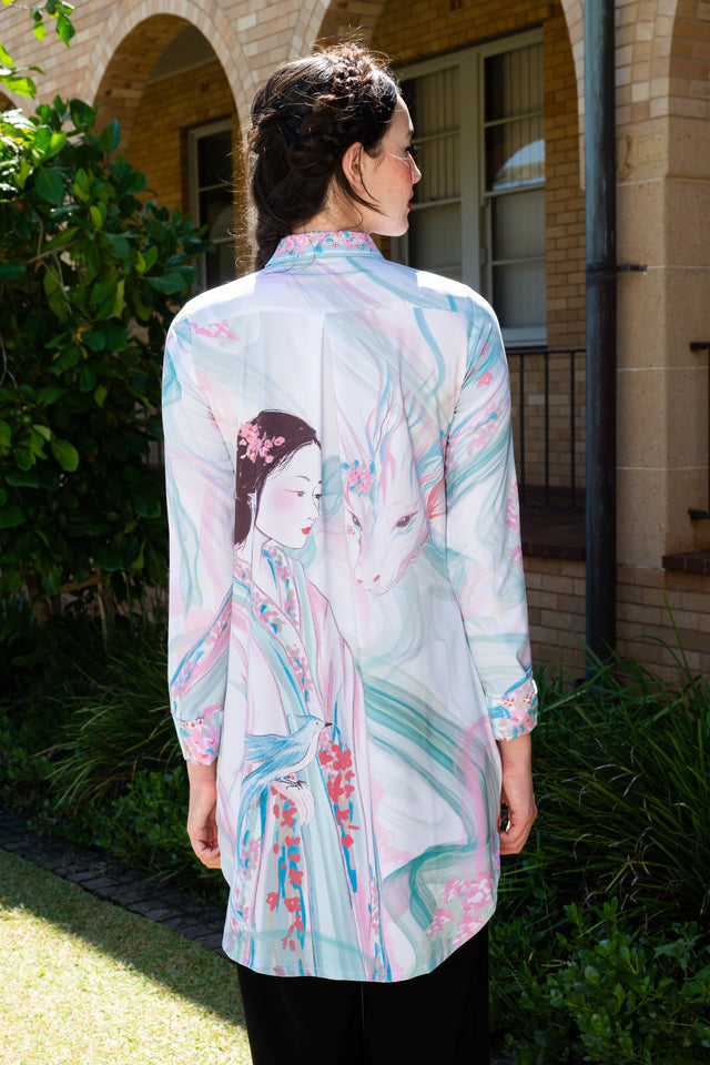 Women’s long sleeve shirt dress featuring pastel fantasy print, button front closure and mythical deer inspired artwork