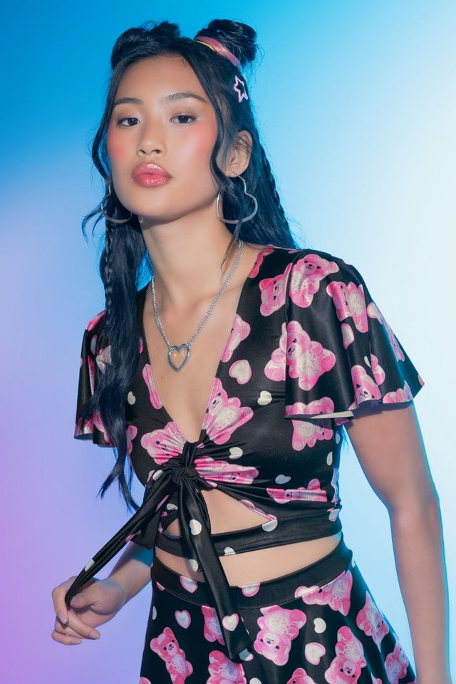Cropped Rio top featuring colourful gummy bear skeleton artwork, shiny stretch fabric, flounced cap sleeves, a front cut-out and a removable tie for playful alternative styling.