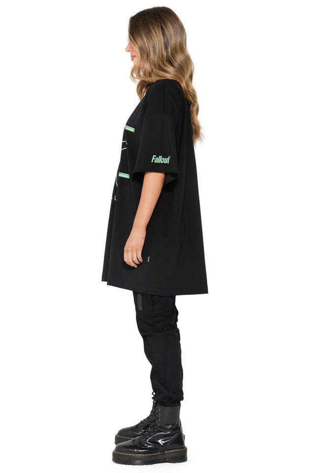 Model styled in Fallout x BlackMilk HP Stats Giant Tee showing Vault Boy outlined in neon green across the front.