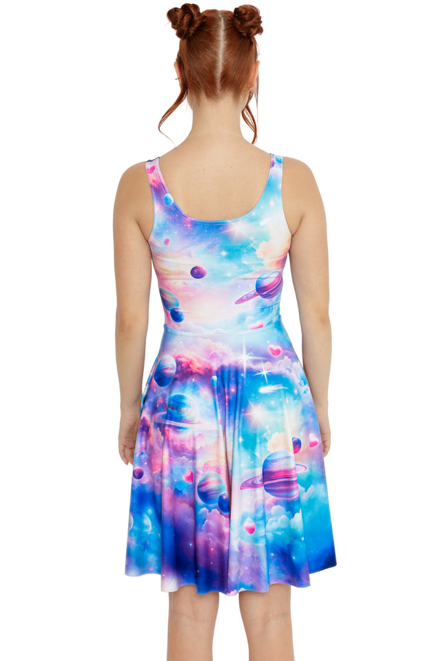 Pastel cosmic dress with swirling galaxy artwork, floating planets and a flared skirt, worn with chunky black boots