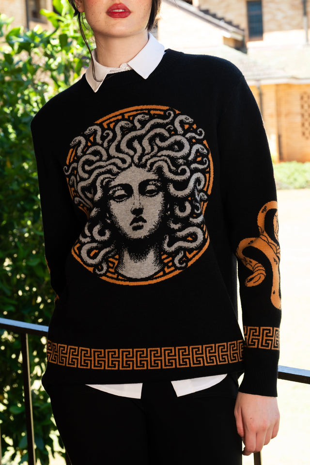 Medusa Crew Knit Sweater close-up of Medusa face graphic with snake hair and contrast orange Greek key knit detail