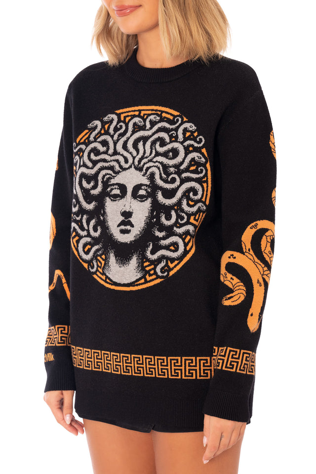 Medusa Crew Knit Sweater close front image showing detailed Medusa face graphic, monochrome snake hair knit pattern and orange Greek inspired circular motif
