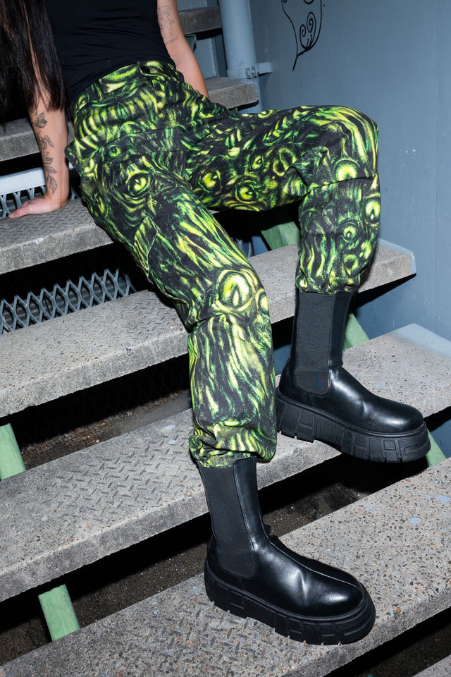 BlackMilk Mesmereyes Cargo Pants – green hypnotic eyeball print cotton cargo Halloween pants with vegan leather trims, part of the BlackMilk Clothing Halloween collection