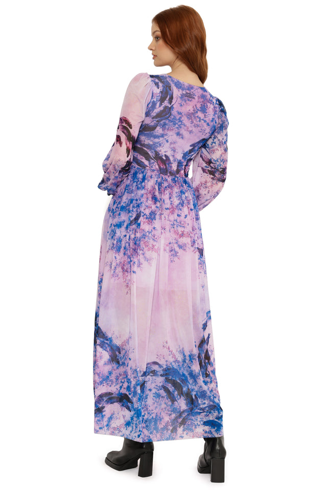 Woman wearing a long, floral-patterned dress on a white background