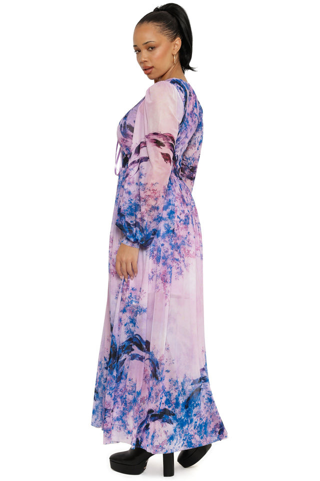Woman wearing a long, floral-patterned dress on a white background