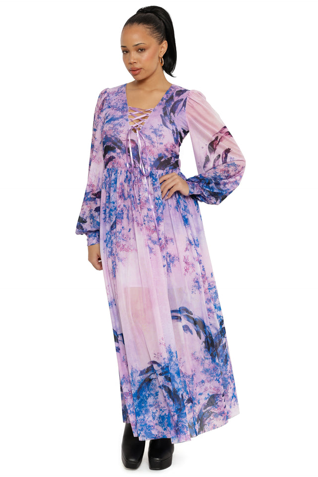 Woman wearing a long, floral-patterned dress on a white background