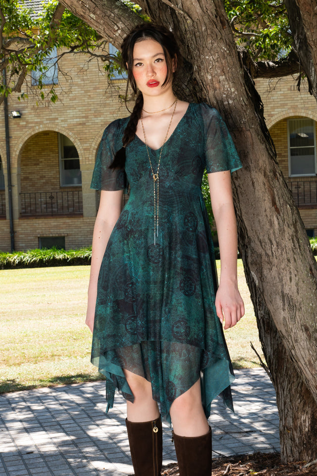 Dark green printed handkerchief dress with flutter sleeves, layered semi sheer skirt, uneven hemline and Celtic inspired design for romantic statement dressing