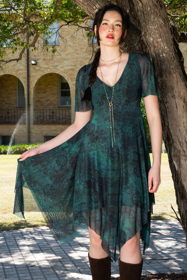 Green handkerchief hem dress with short flutter sleeves, v neckline and soft draping skirt in an earthy fantasy inspired print