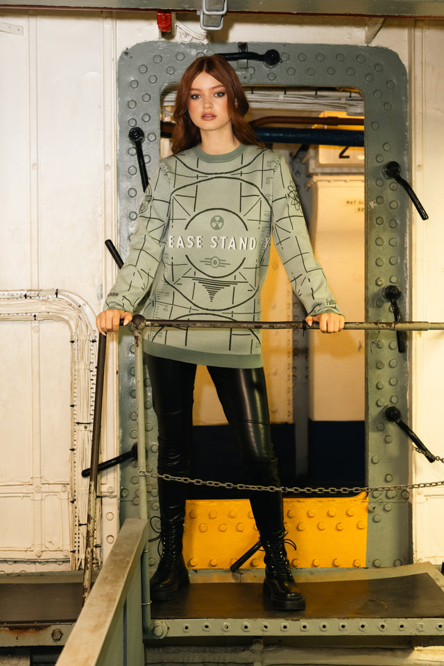 Person wearing a green sweater with text inside a metal frame.