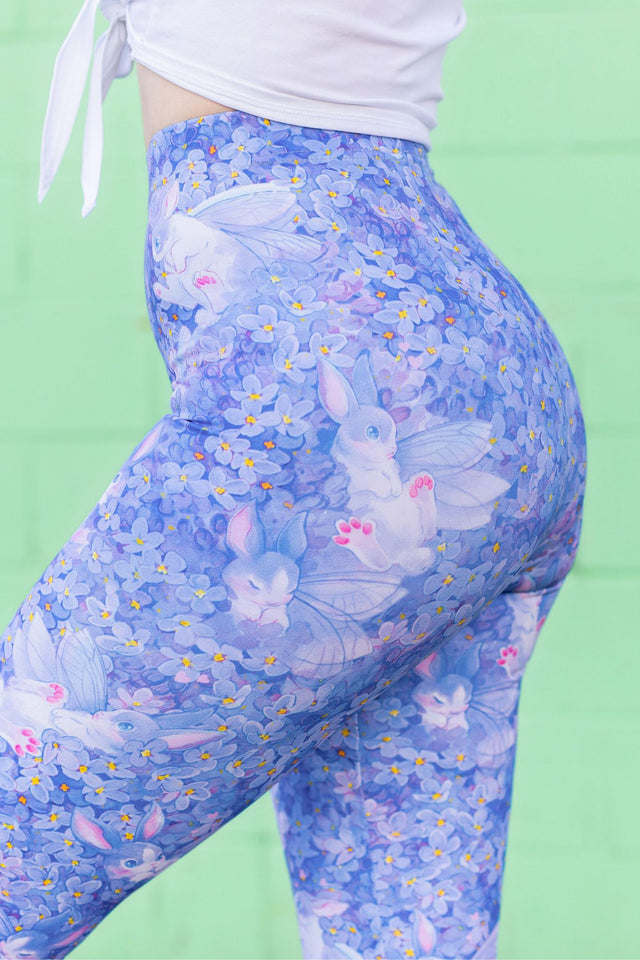 Blue leggings with bunny and flower pattern on a green background
