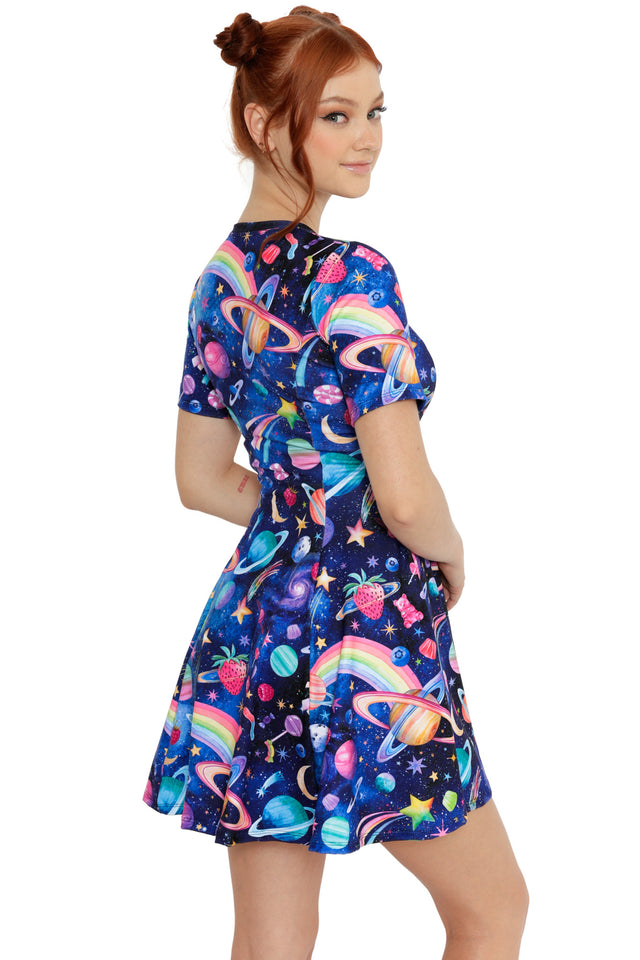 Side view of space-themed skater dress with vibrant planets, rainbows and playful cosmic print