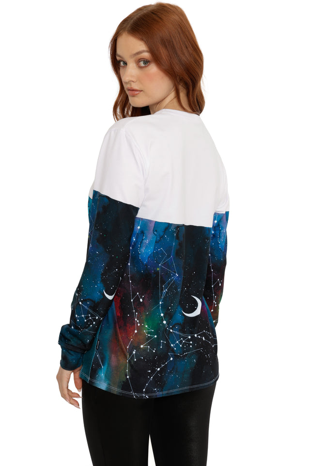 Woman wearing a white and blue galaxy-themed long sleeve t-shirt on a white background