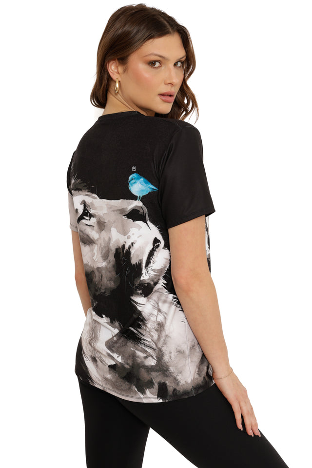 Woman wearing a black t-shirt with a graphic design of a wolf and a blue bird on a white background
