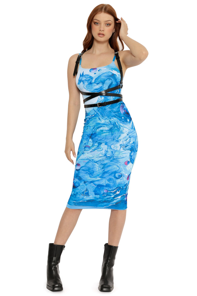 Woman wearing a blue patterned dress with black straps on a white background