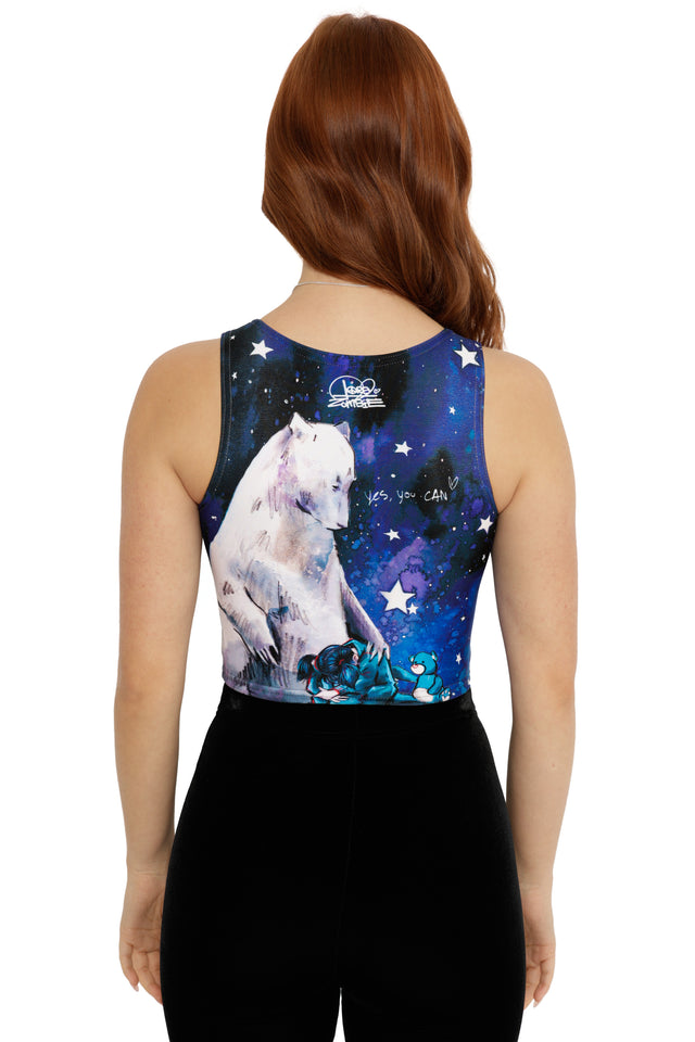 Woman wearing a sleeveless top with a white bear and starry night design on a blue background.