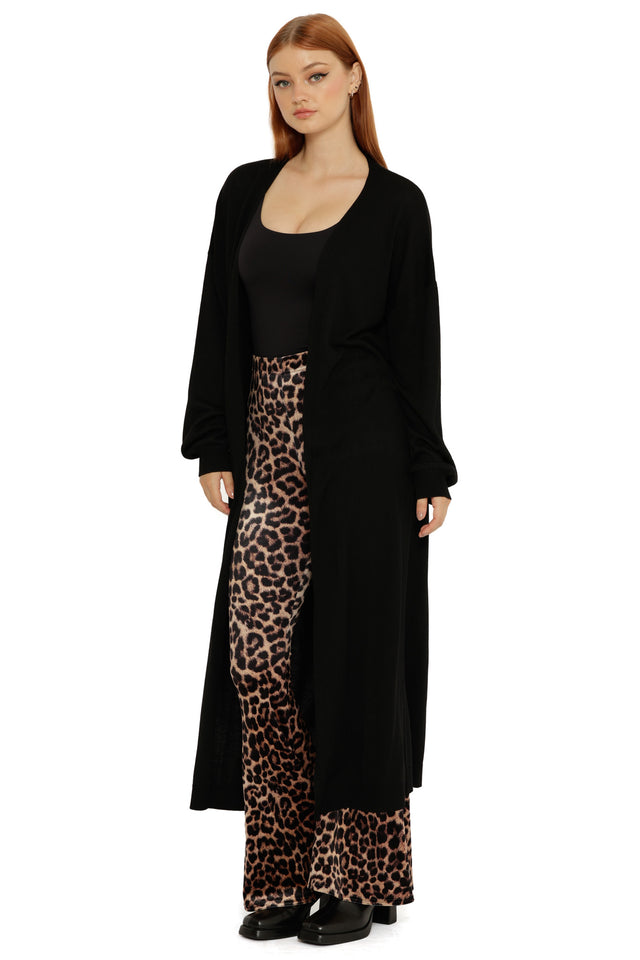 Long black knit Super Cardigan styled open, featuring a cozy fabric and fluid movement through the hem.