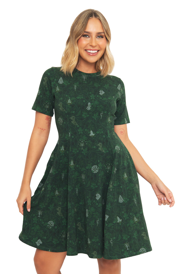 Front view of a model wearing the BlackMilk Bag End Wallpaper Longline Evil Tee Dress in forest green, featuring a hobbit-hole wallpaper-inspired print from the Lord of the Rings collection.