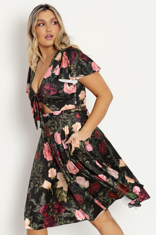 black dress with pink roses Ros Turns Up the Heat On Cocktail Attire In a Micro-Mini Lace Dress