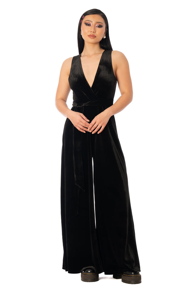 Back view of the black velvet wide-leg jumpsuit. League of Legends K/DA x BlackMilk black velvet wide-leg jumpsuit with a deep V neckline and sleeveless bodice.