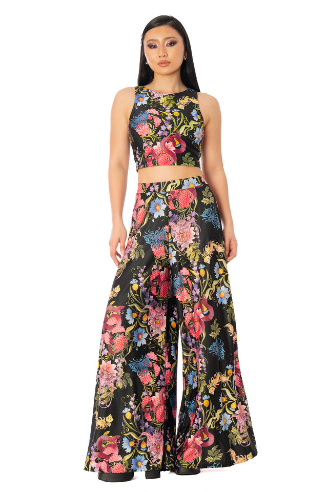Model wearing the wide-leg printed palazzo pants with a matching cropped top. League of Legends K/DA x BlackMilk wide-leg palazzo pants with a colourful floral and animal-inspired K/DA print.